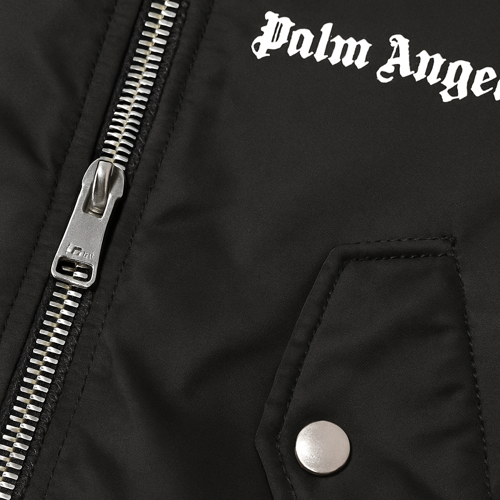 CHAQUETA NEGRA PALM ANGELS ESTILO BOMBER, CON CUELLO DE TELA, ABERTURA DE CIERRE METÁLICO Y BOLSILLOS CON BOTONES A PERSIÓN. LOGOTIPO EN PECHO