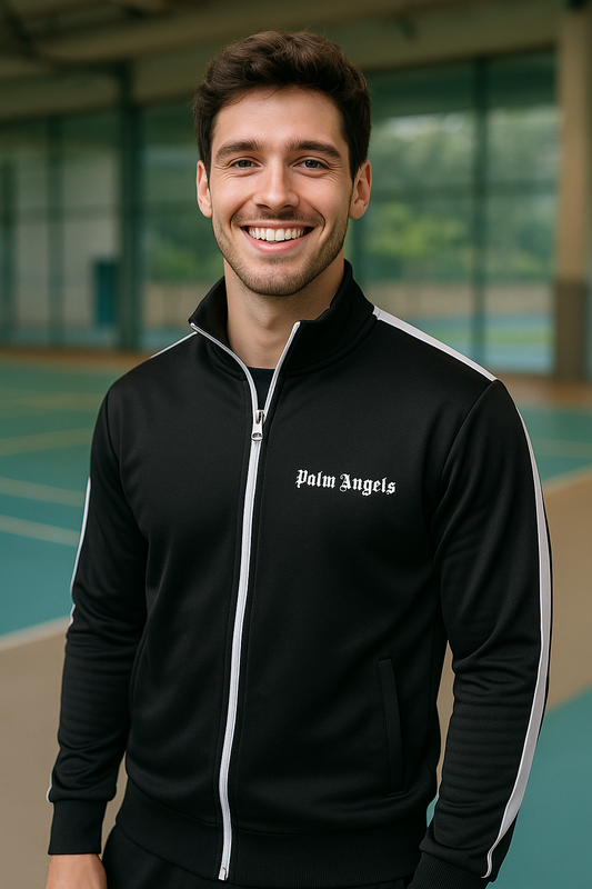 CHAQUETA NEGRA DEPORTIVA PALM ANGELS, CUELLO ALTO, ABERTURA CON CIERRE BLANCO, BOLSILLOS ABIERTOS Y LOGOTIPO EN PECHO. LINEAS VERTICALES EN BRAZOS